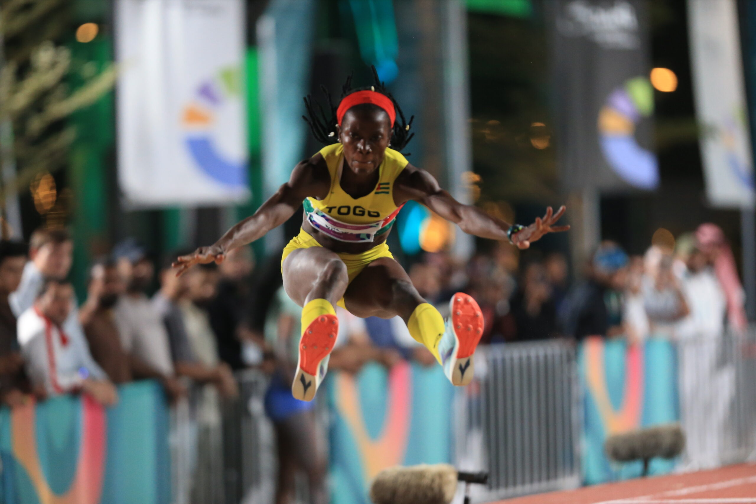 Fayza en plein saut, en plein vol, juste avant de retomber dans le sable. 
